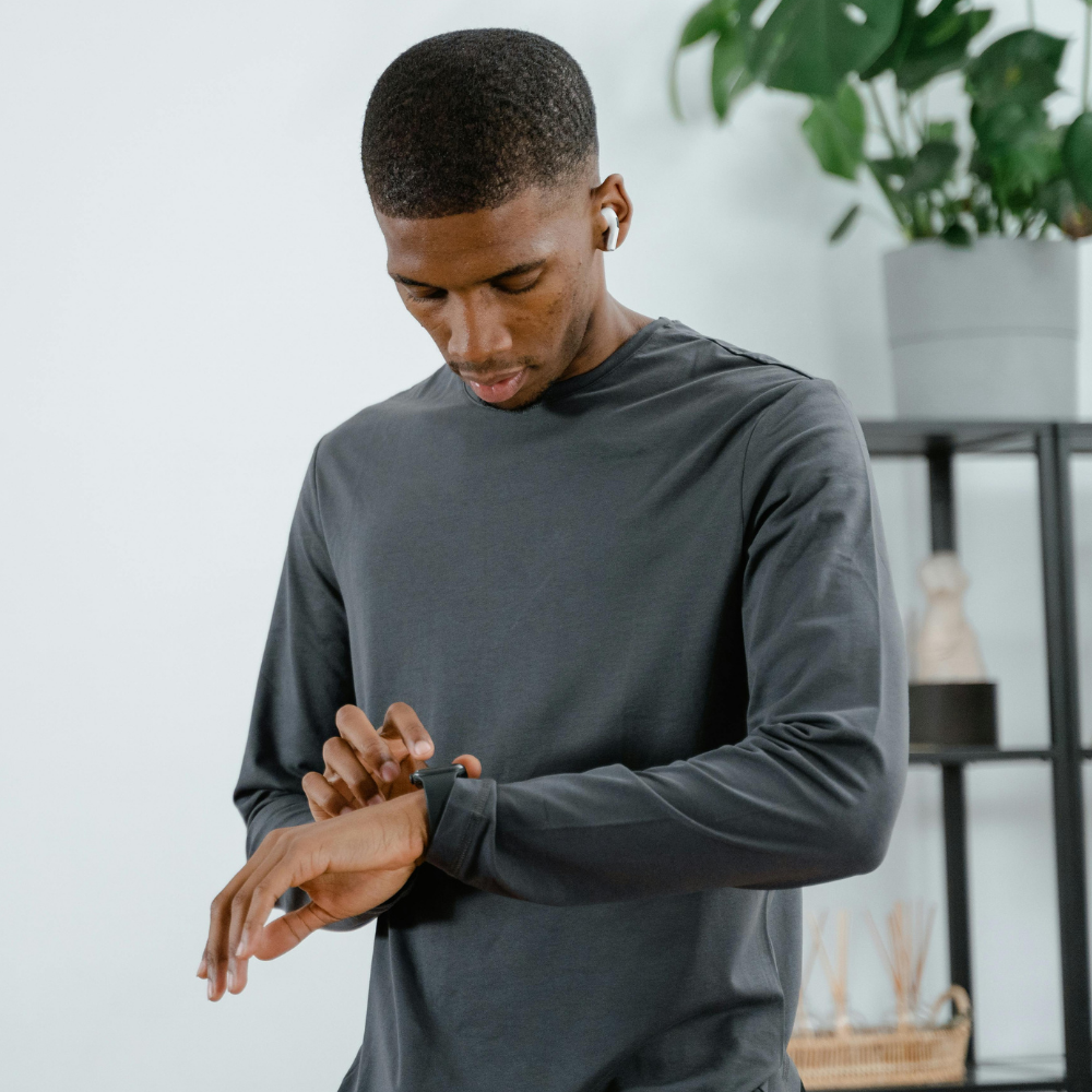 Man wearing a long-sleeve shirt checking his watch, embodying the essence of Time That Defines You.