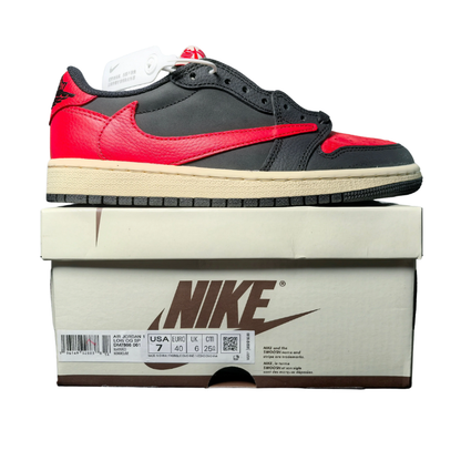 Nike Travis Scott x Air Jordan 1 Low Bred Sneakers on a shoe box, showcasing the iconic red and black colorway.